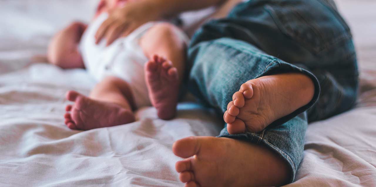pies de niño y de bebé en colchón pies de niño y de bebé en colchón