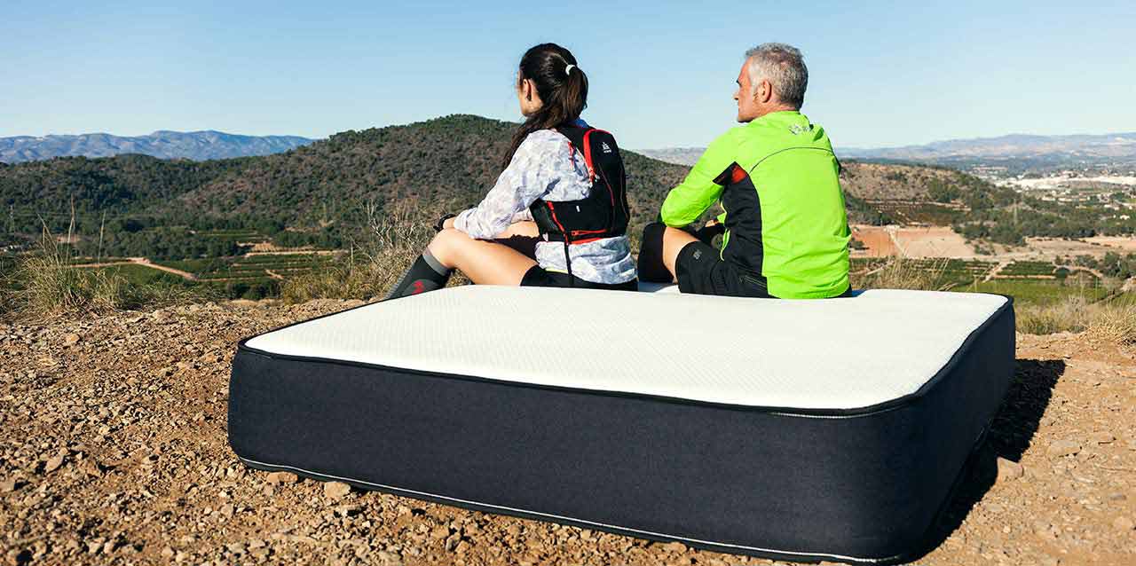 pareja en montaña sentada en colchón