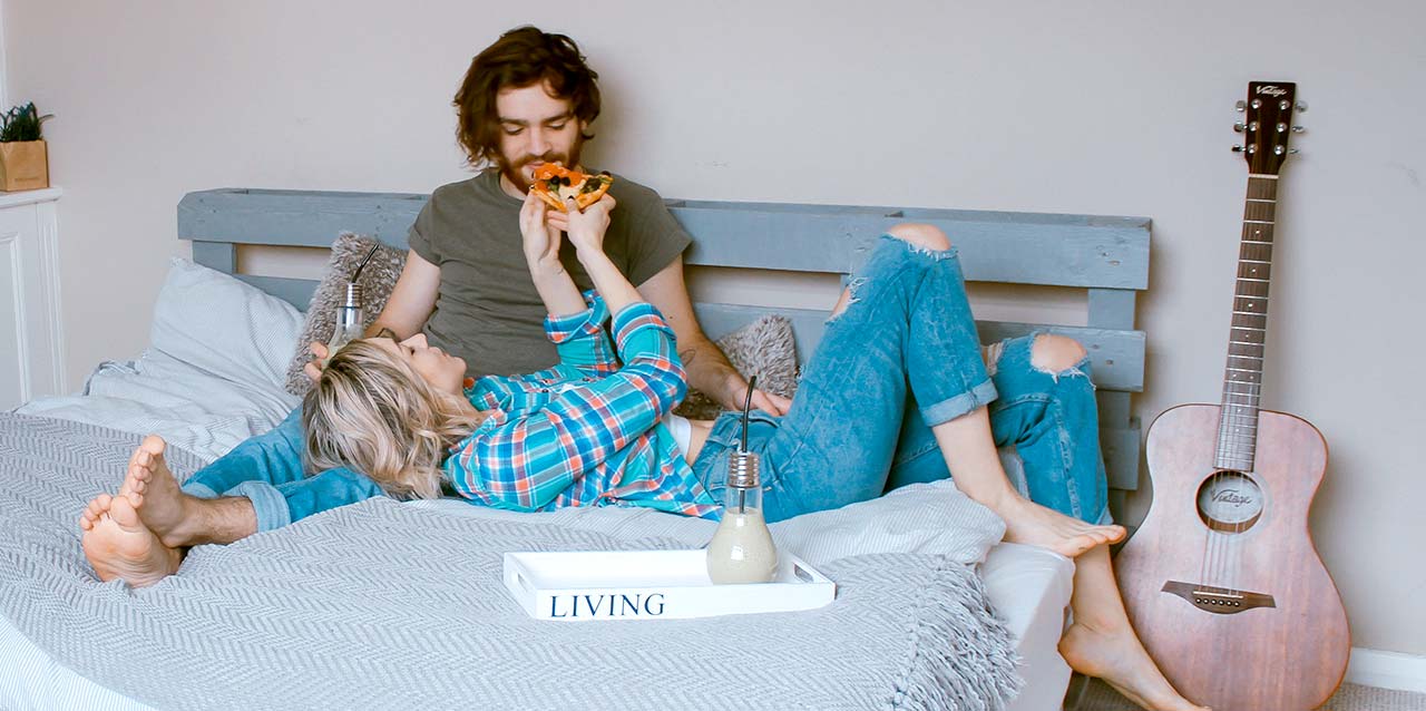 pareja comiendo pizza en la cama pareja comiendo pizza en la cama