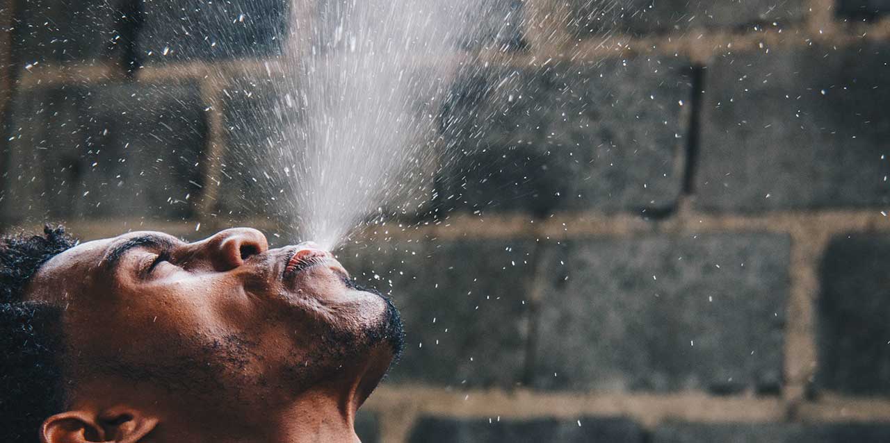 hombre escupiendo agua