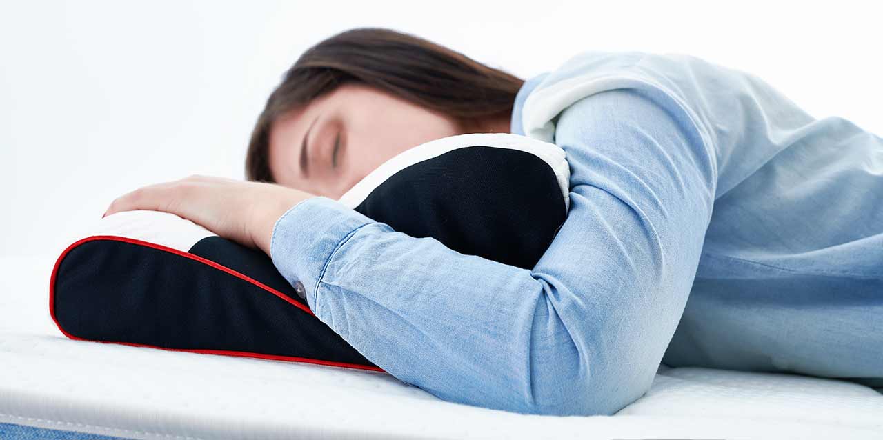 mujer durmiendo bocabajo en almohada cervical
