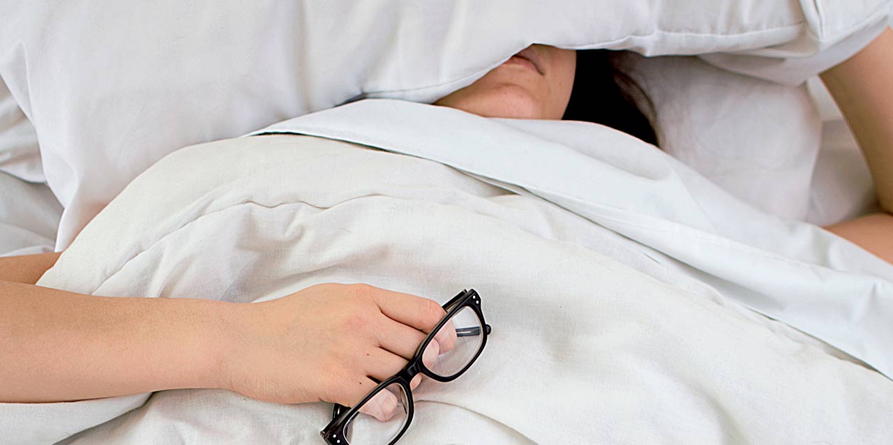 mujer tapada con gafas en la mano