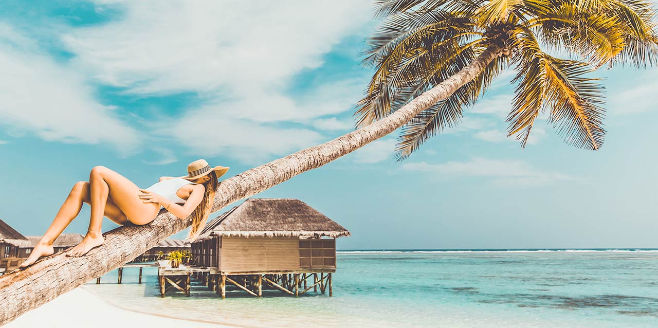 mujer tumbada en palmera junto a playa mujer tumbada en palmera junto a playa