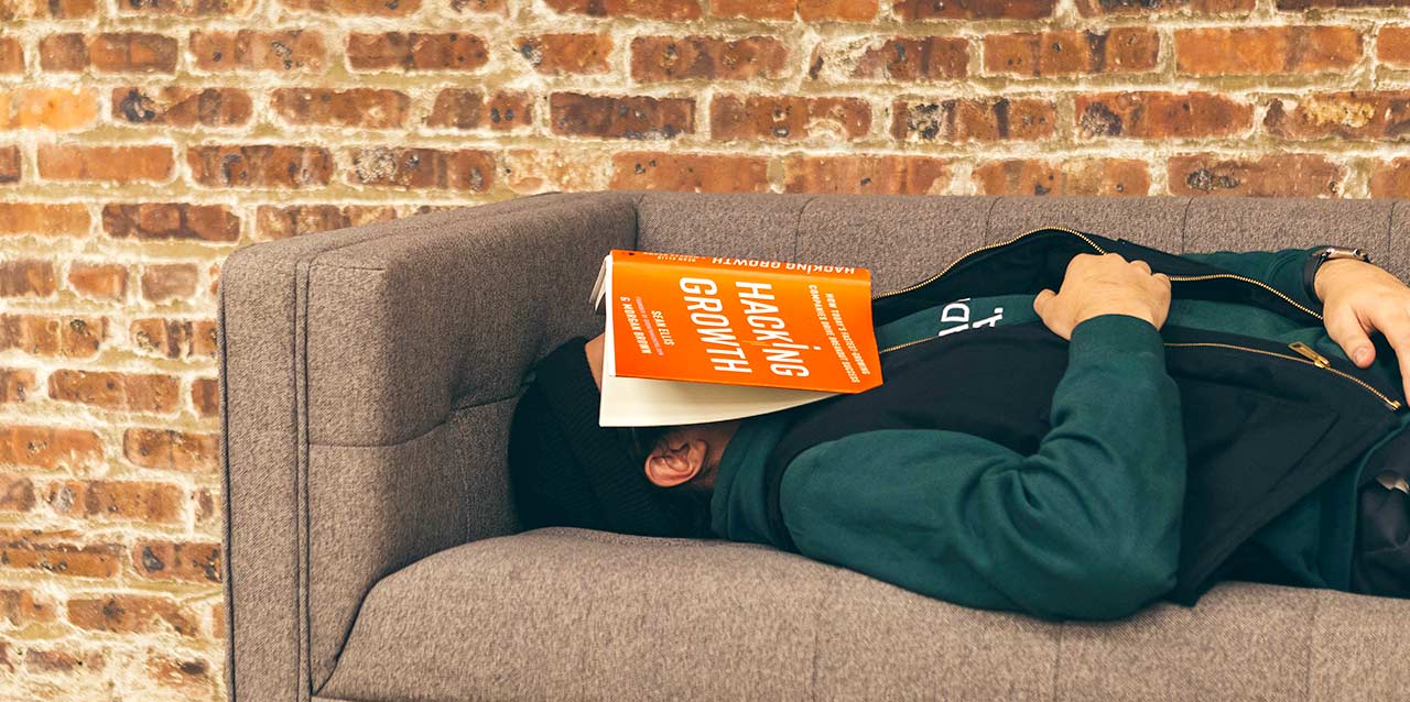 chico durmiendo en sofá con libro en la cabeza