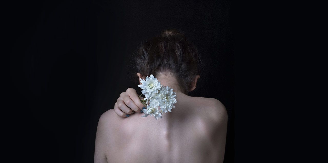 que-es-la-cifosis-y-como-corregirla-1 mujer con ramo de flores en la espalda