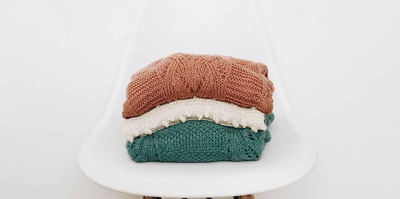 jerseys de lana doblados en silla