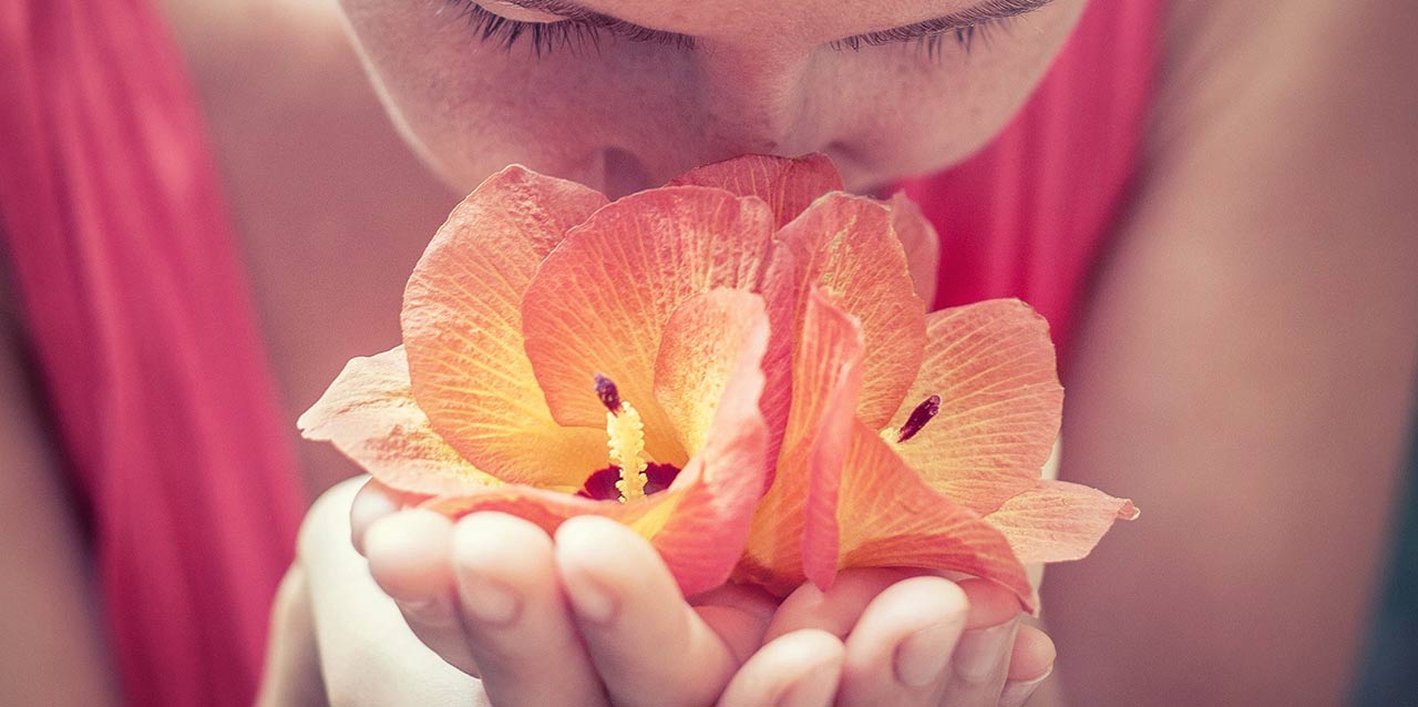niña oliendo flores