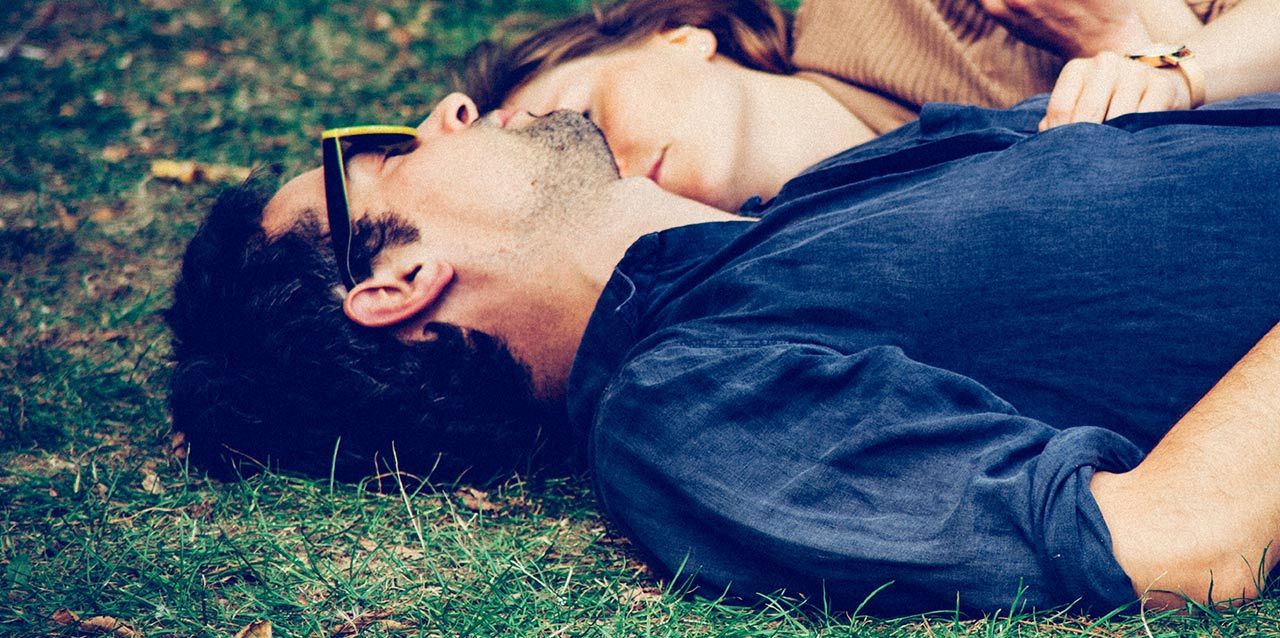 pareja tumbada en cesped