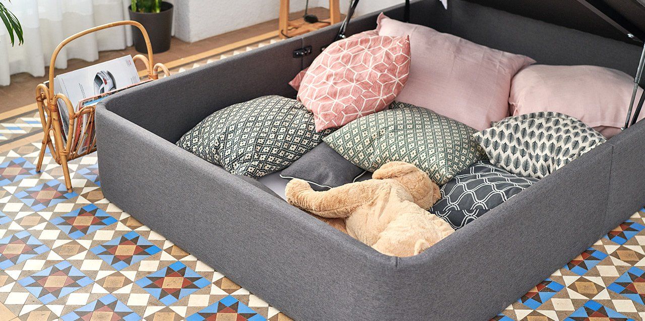 canapé abierto con cojines y peluches