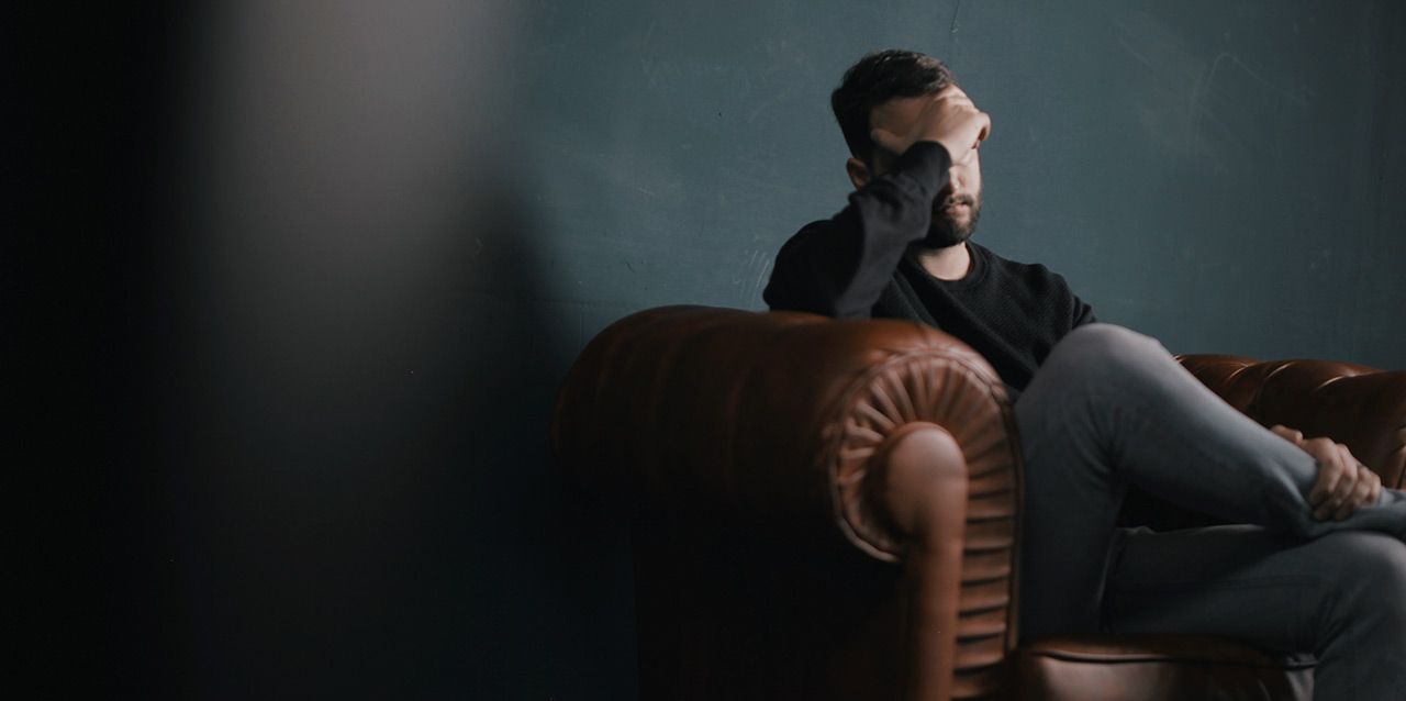 Hombre con dolor de cabeza en sillón Hombre con dolor de cabeza en sillón