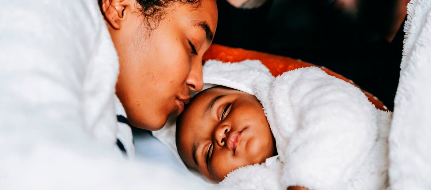 madre besando en la frente a su hijo