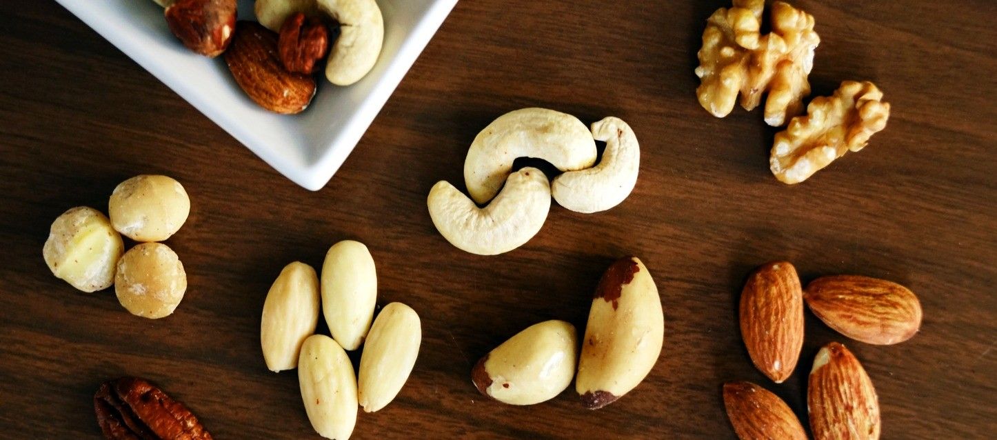 frutos secos distintos frutos secos dispuestos sobre una mesa de madera como avellanas, almendras, nueces, anacardos