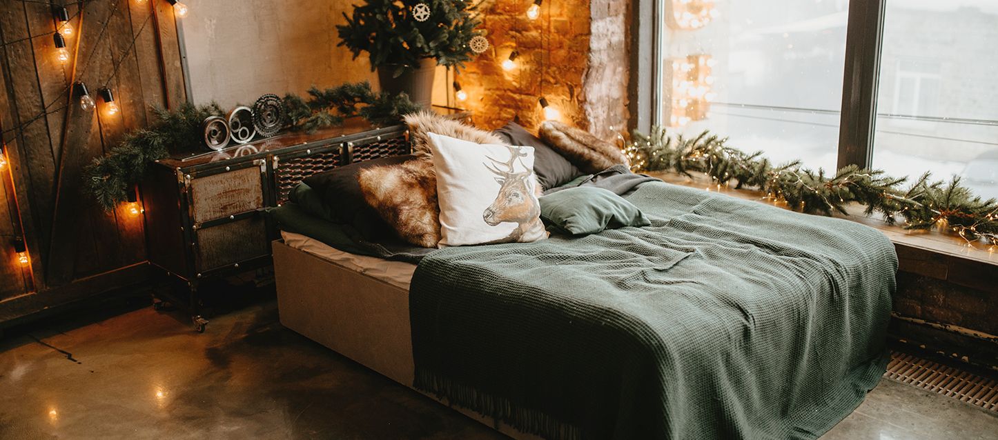 Qué son las sábanas de franela cama con sabanas de franela, 8 cojines, cabecero rustico en una habitación con decoracion navideña
