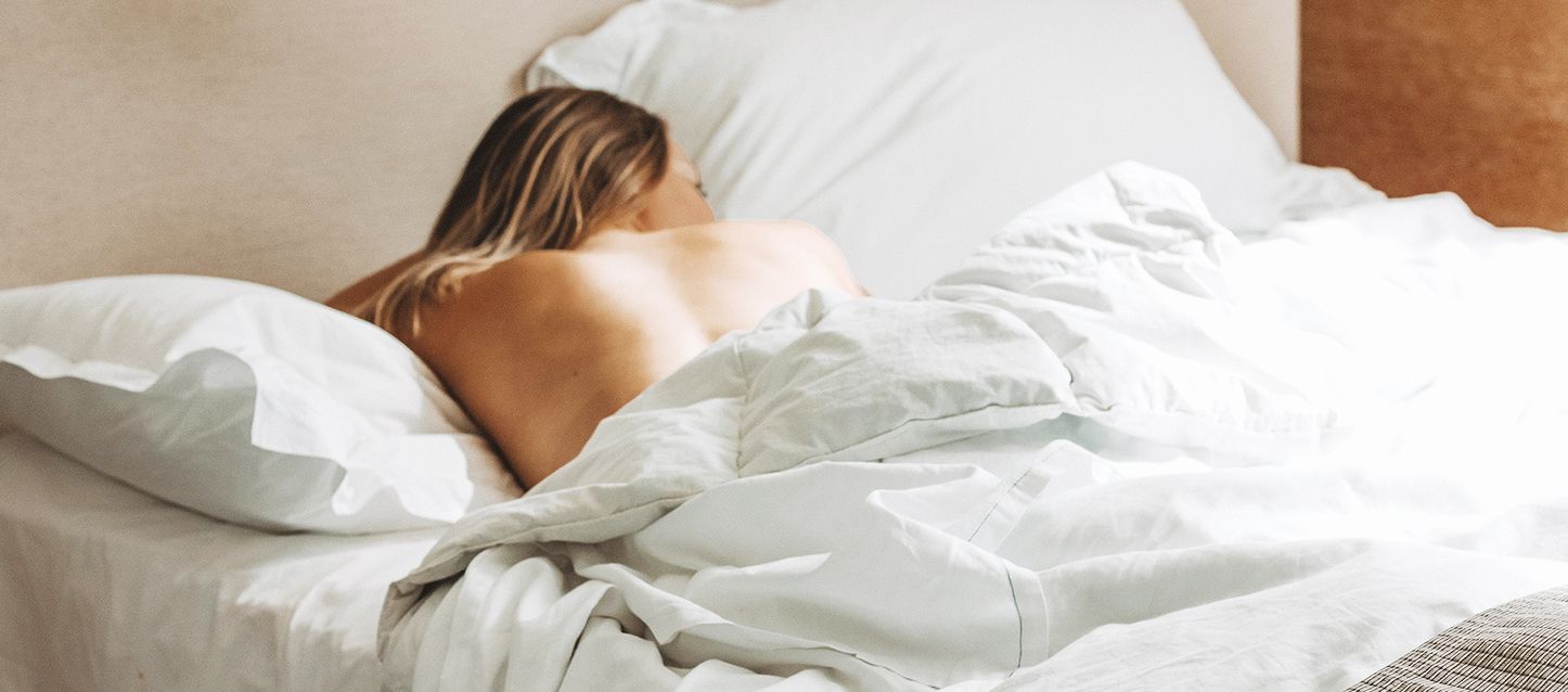 chica de pelo largo rubio durmiendo boca abajo tapada con el edredon