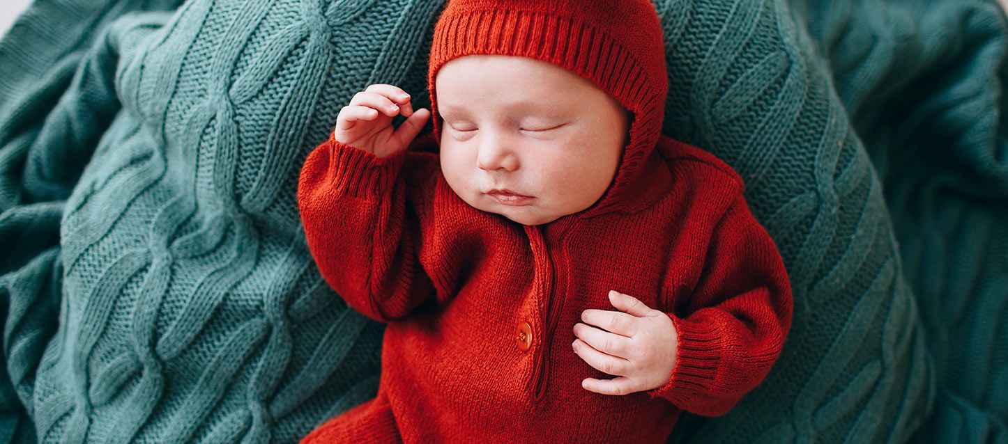 Problemas de sueño en los bebés bebe durmiendo boca arriba con pijama rojo