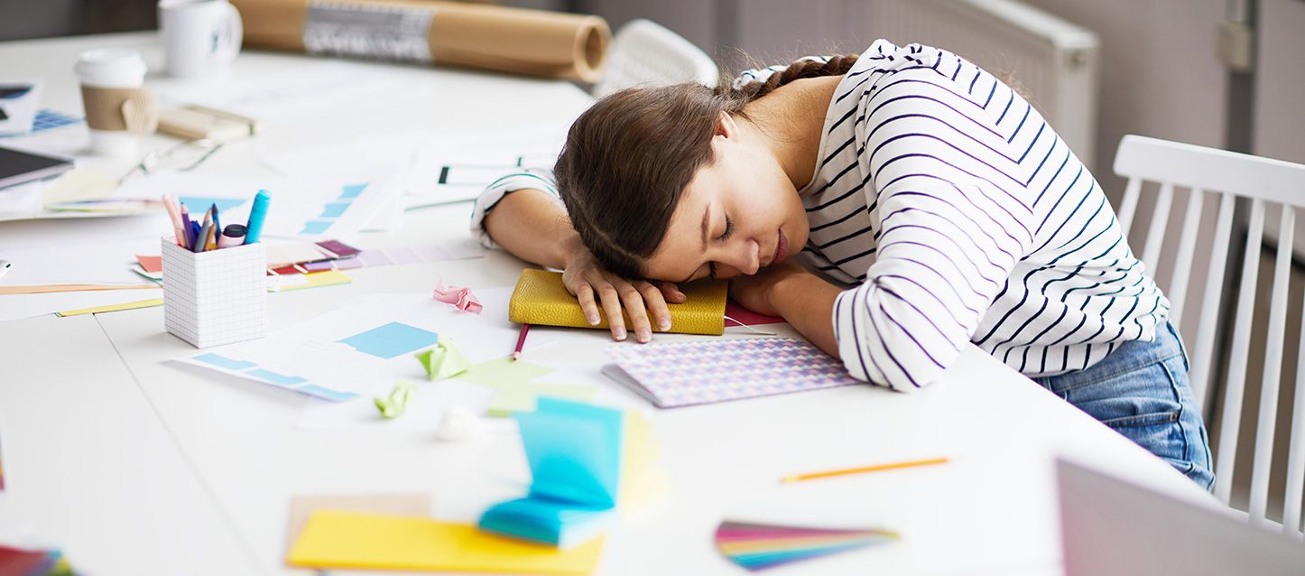 Qué hacer para no dormir mujer dormida sobre el escritorio sobre su agenda con la mesa con utensilios de diseño