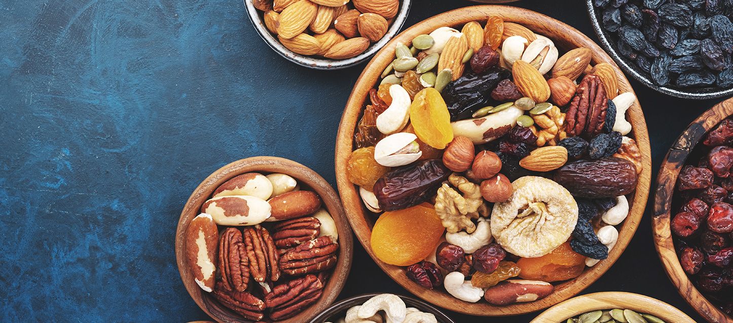 propiedades de los frutos secos beneficiosos para el descanso varios boles con frutos secos y frutas deshidratadas como anacardlos, nueces, orejones, datiles, pipas de calabaza y coquitos
