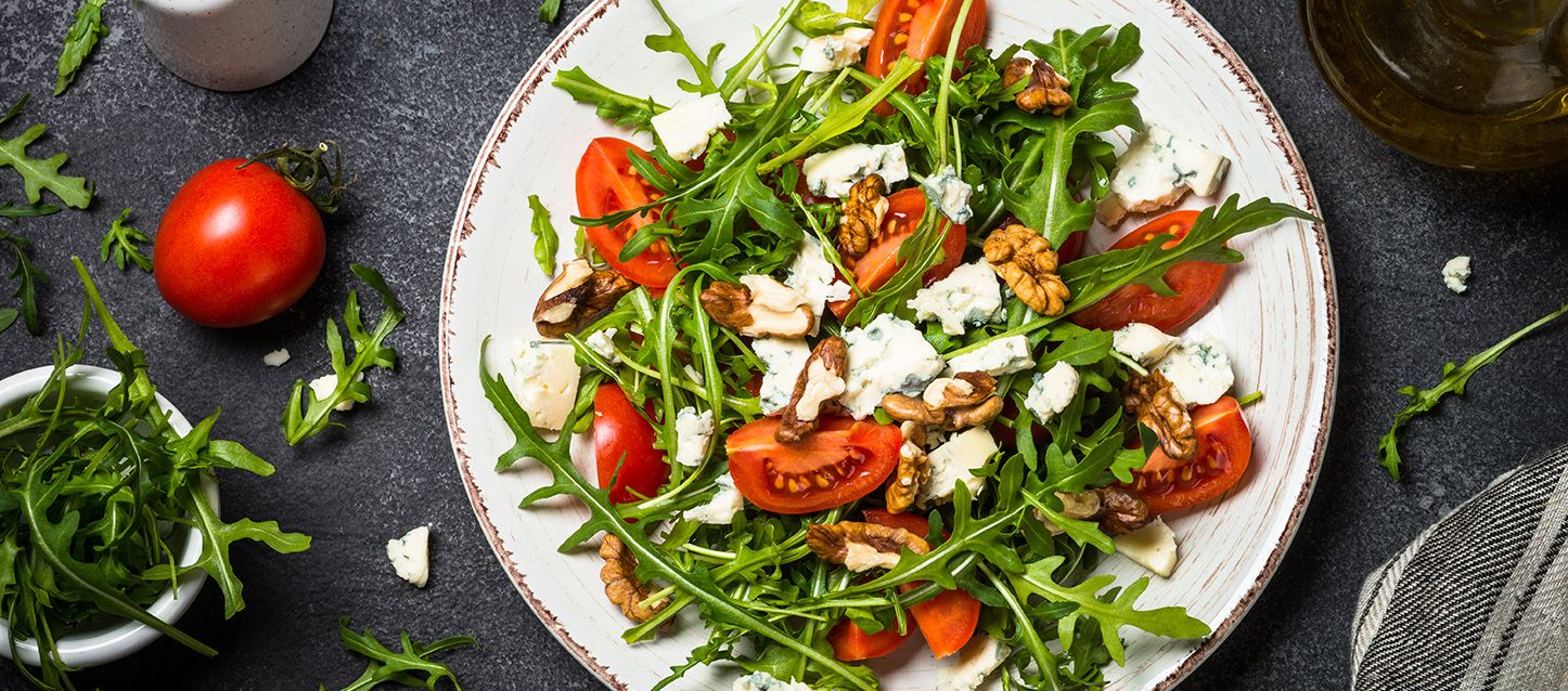 plato de ensalada con rucula, queso gorgonzola, tomate y nueces
