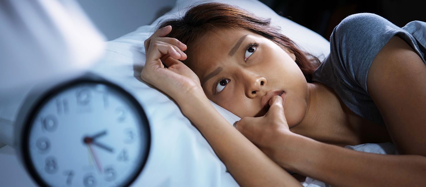 revertir el insomnio crónico chica metida en la cama sin poder dormir mirando hacia arriba con gesto preocupado