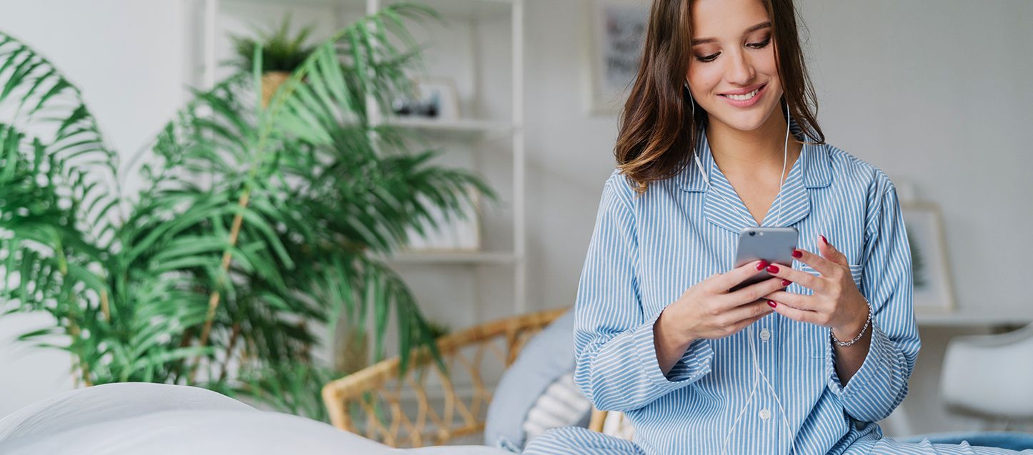 blog-1-1 Chica de pelo largo moreno y pijama a rayas azules y blancas usando las mejores apps para controlar el descanso