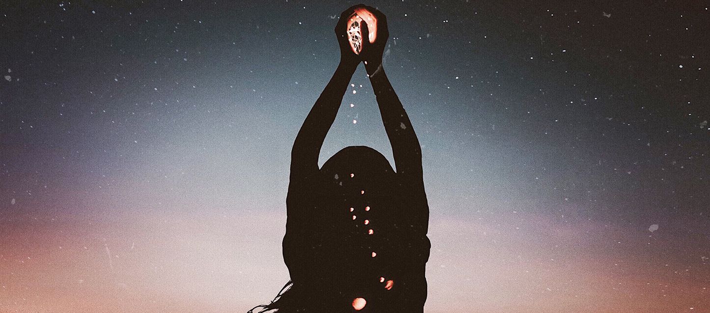 blog-1-1 mujer con las manos en el aire al anochecer con luces entre sus manos