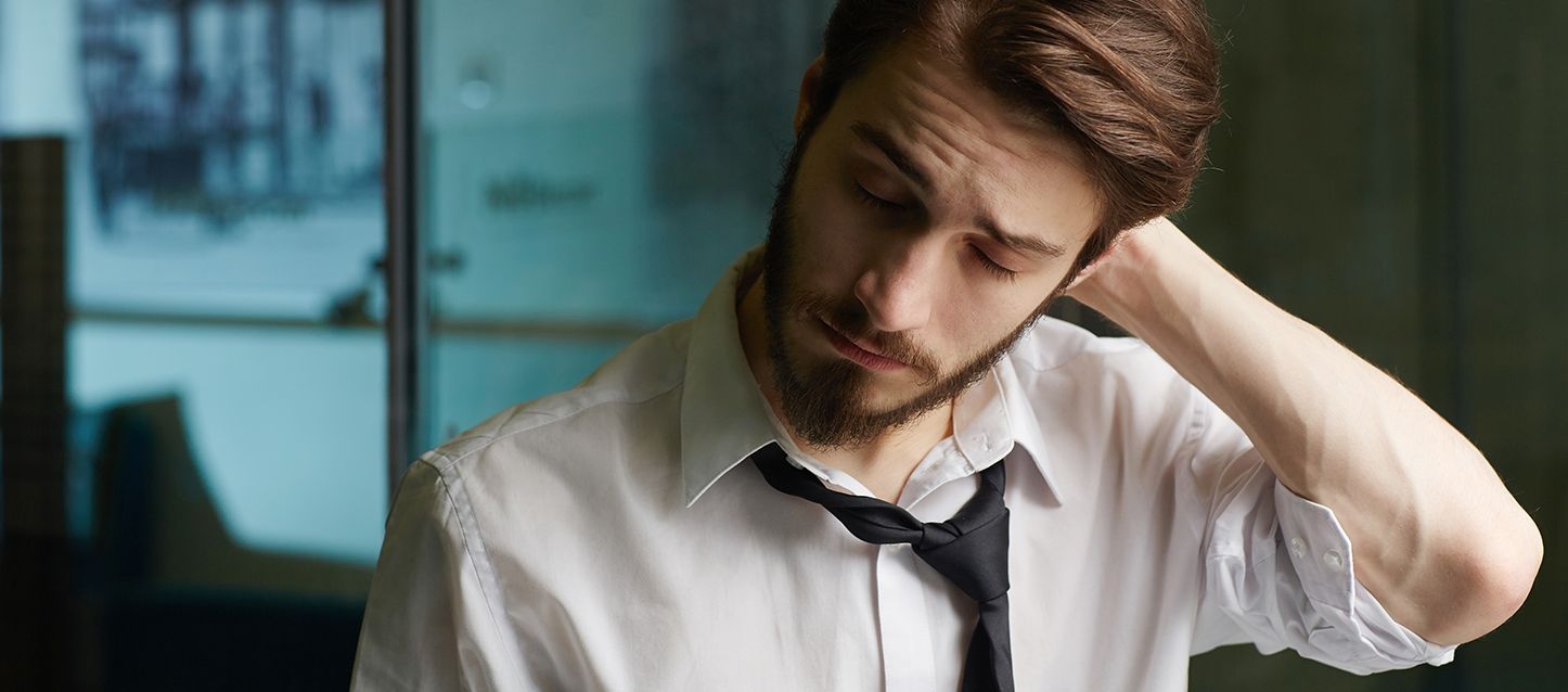 blog-1 hombre con barba vestido con camisa blanca y corbata negra con la mano en la cabeza y gesto dolorido