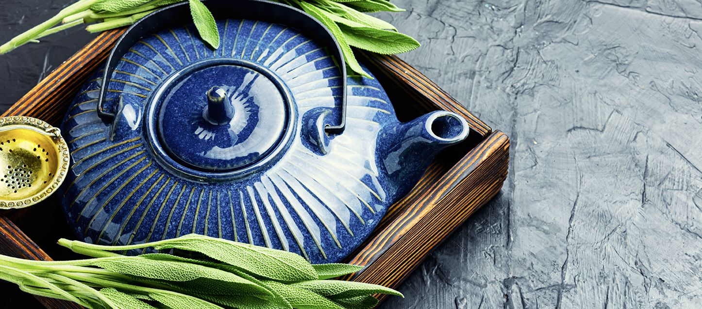 tetera de ceramica dentro de una caja de madera con té de salvia para dormir