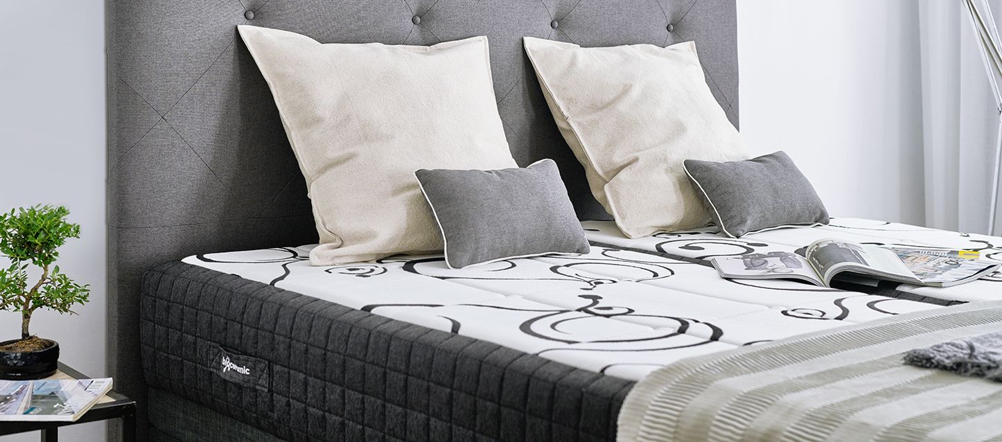 blog-1 colchon, cojines, cabecero, 2 libros sobre la cama y una manta doblada en un lado