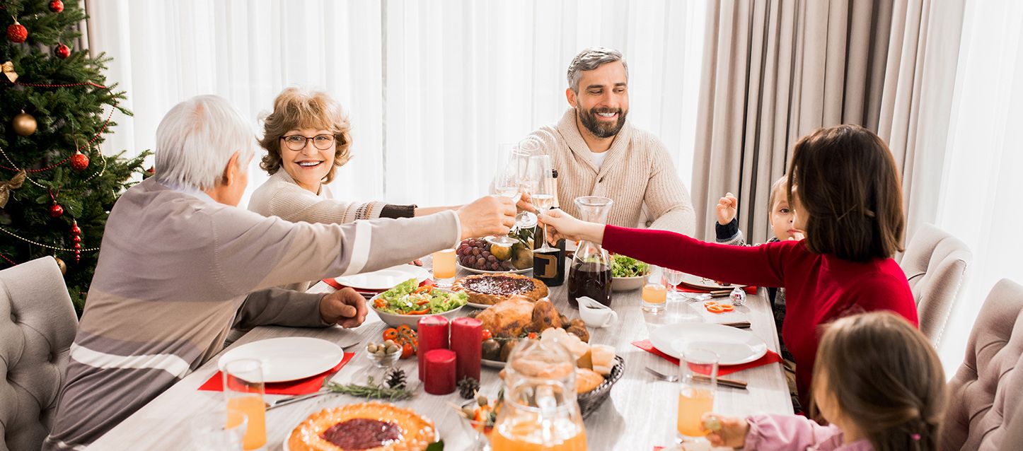 Los básicos de la decoración invernal en las habitaciones Familia compuesta por dos abuelos y dos padres sentada en la mesa comiendo con dos hijos pequeños